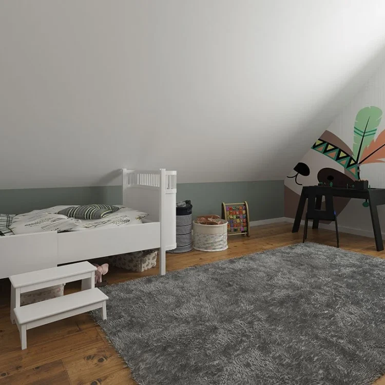 Kinderzimmer mit weißem Hochbett, grauem Teppich und schwarzem Schreibtisch unter der Dachschräge