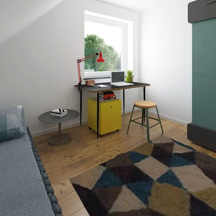 Kinderzimmer im Dachgeschoss mit Schreibtisch, gelber Rollcontainer, grauem Sofa und geometrischem Teppich