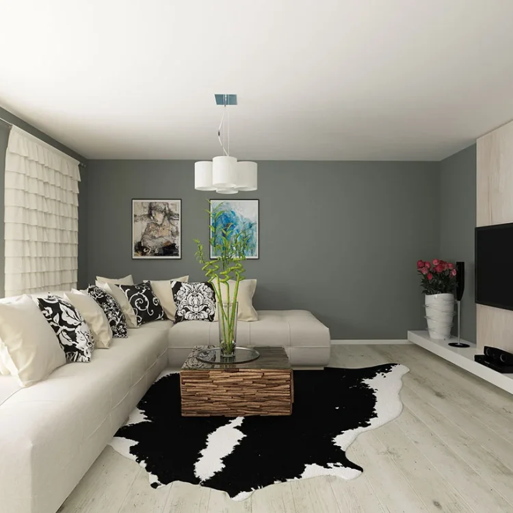 Modernes Wohnzimmer mit grauer Wand, weißem Ecksofa, Holzcouchtisch, Kuhfell-Teppich und TV-Wand aus Holz