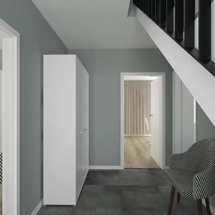 Moderner Flur einer Stadtvilla mit grauer Wand, weißer Treppe, Sessel mit Streifenmuster und Blick ins Schlafzimmer