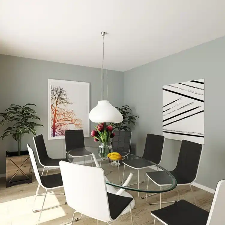 Modernes Esszimmer mit rundem Glastisch, schwarz-weißen Stühlen, grauen Wänden und abstrakten Wandbildern