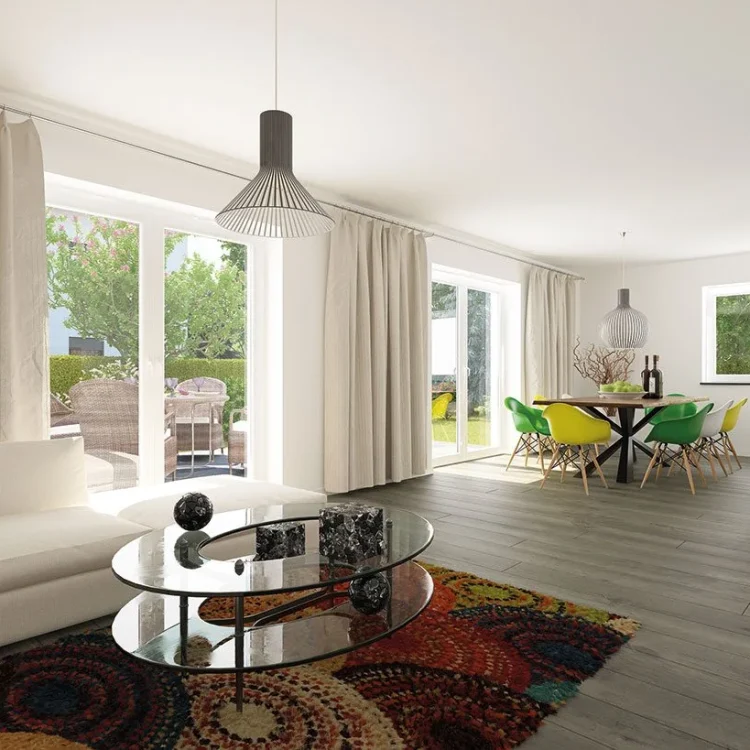 Modernes Wohnzimmer mit weißem Sofa, Glascouchtisch, buntem Teppich und Essbereich mit grün-gelben Stühlen