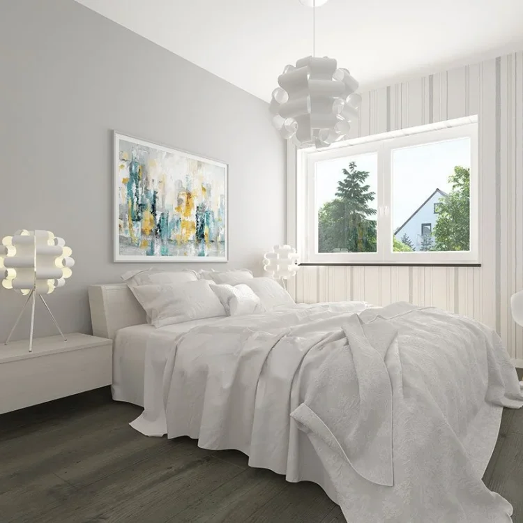 Modernes Schlafzimmer mit grauer Bettwäsche, abstraktem Wandbild, weißem Nachttisch und Blick ins Grüne durch Fenster